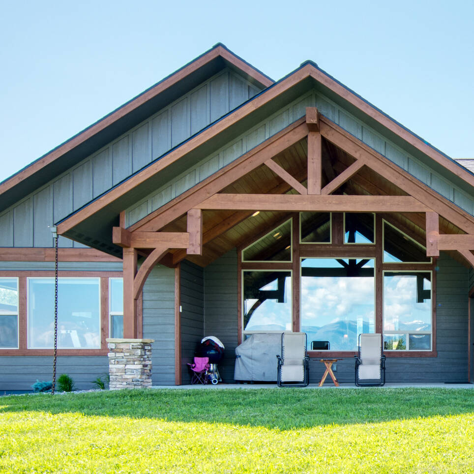 Exterior featuring a custom timber truss on the back of a custom home built by Big Sky Builders in Stevensville, MT
