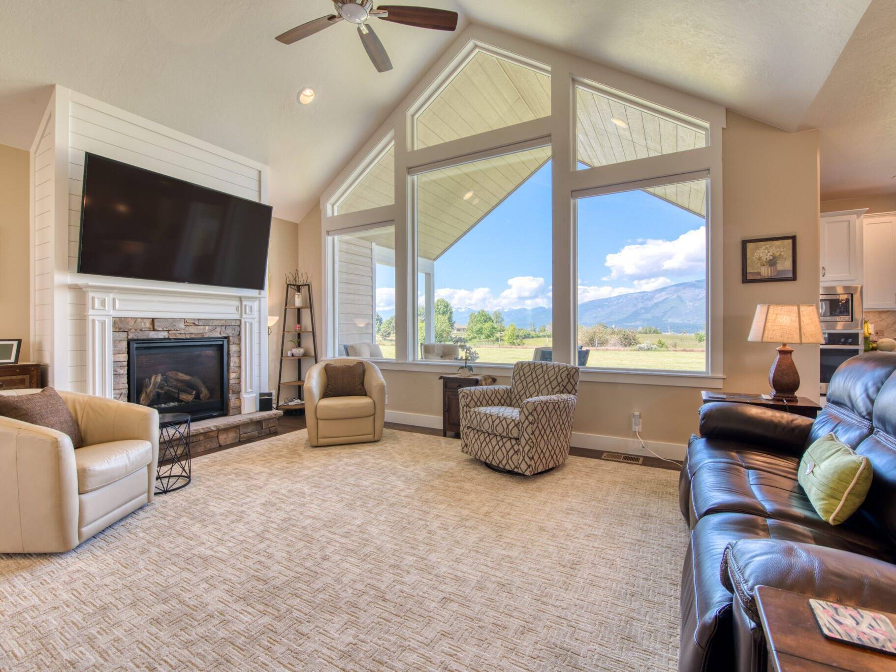 Living room with fireplace and large windows overlooking the Bitterroot valley, in a home built by Big Sky Builders in Hamilton, MT