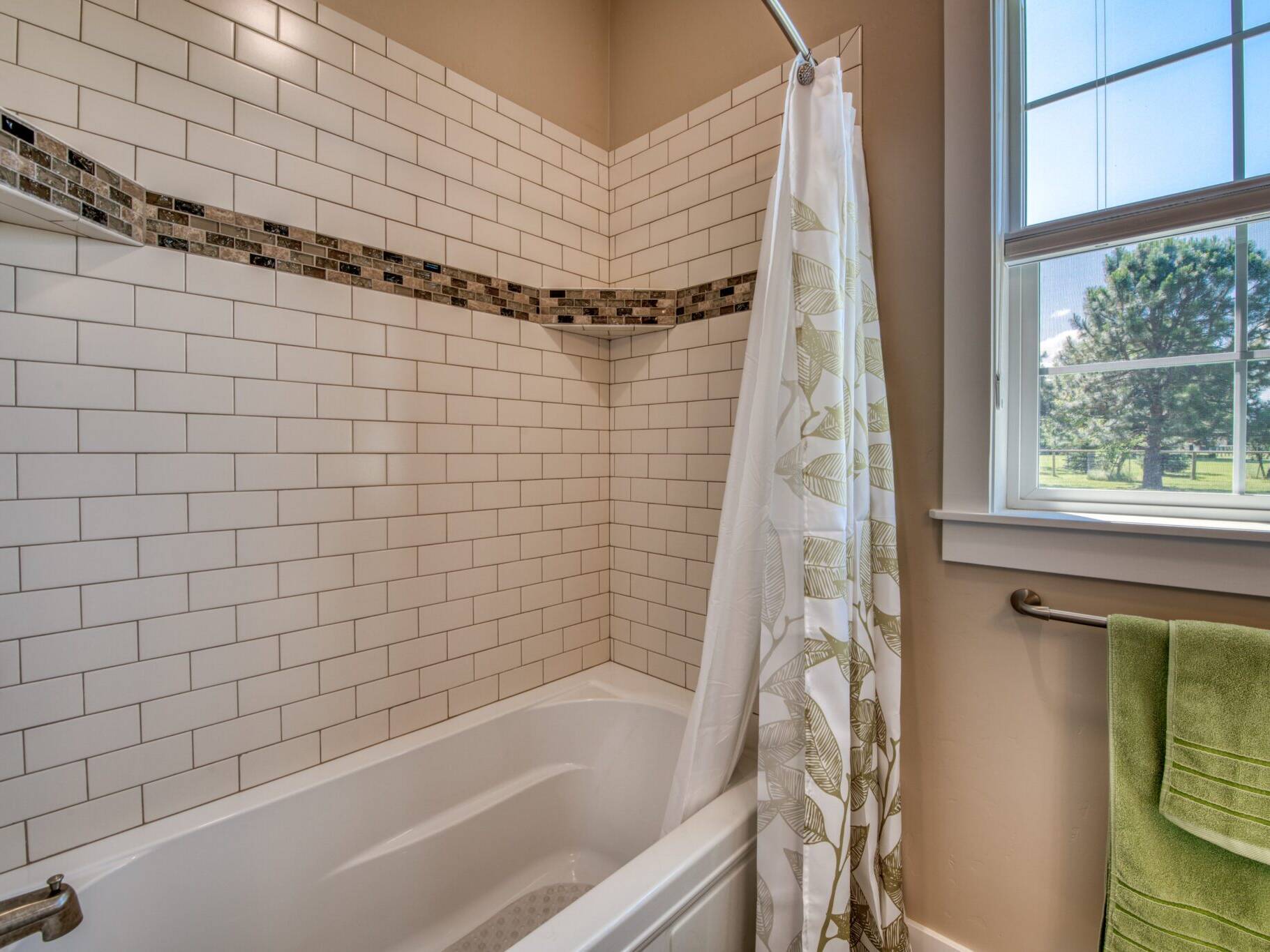 Bathroom tub/shower with tile surround in a custom home built by Big Sky Builders of Montana in Hamilton, MT