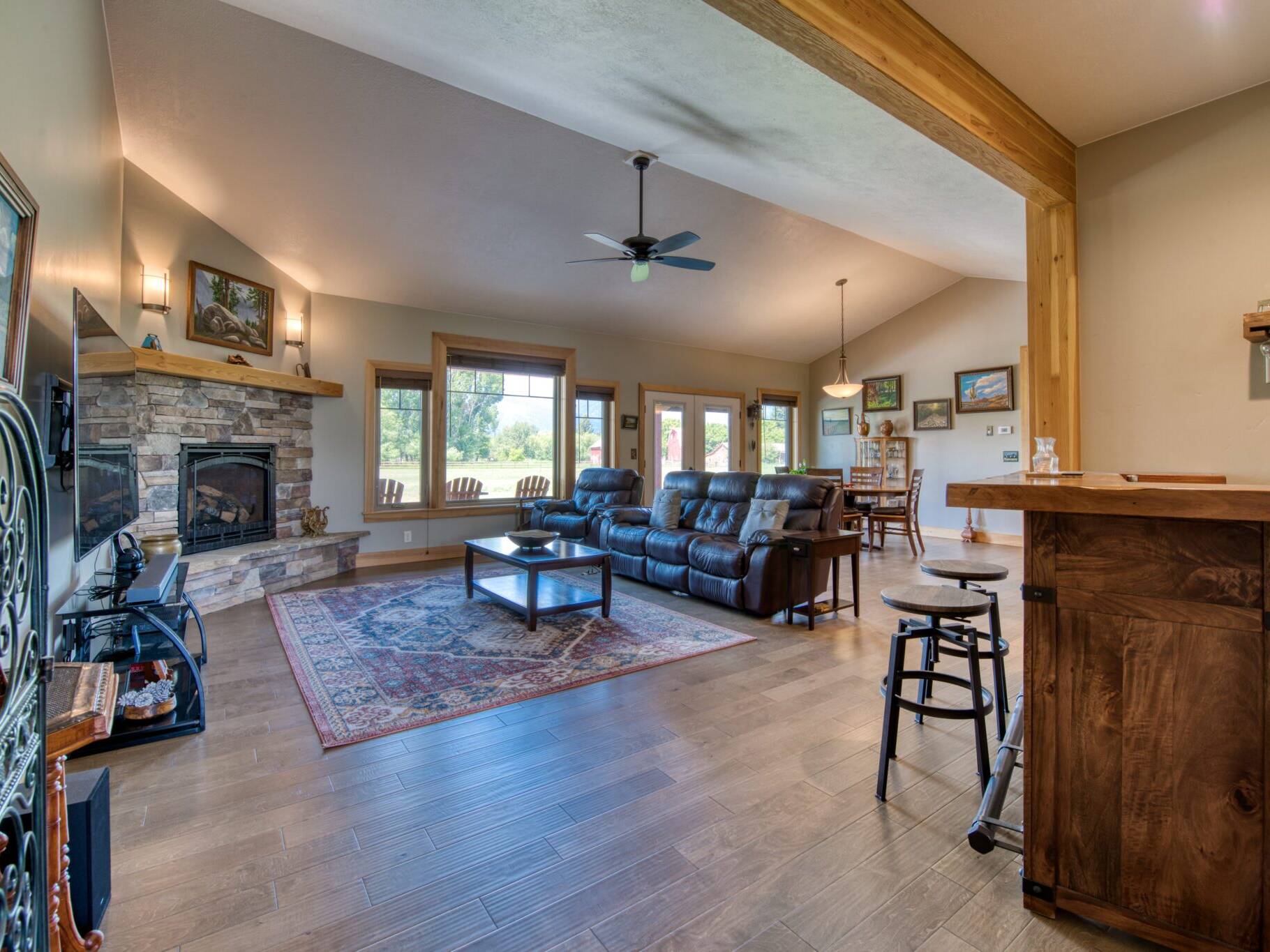 Living room with wood flooring, gas fireplace and wood trim in a custom home in Hamilton, MT