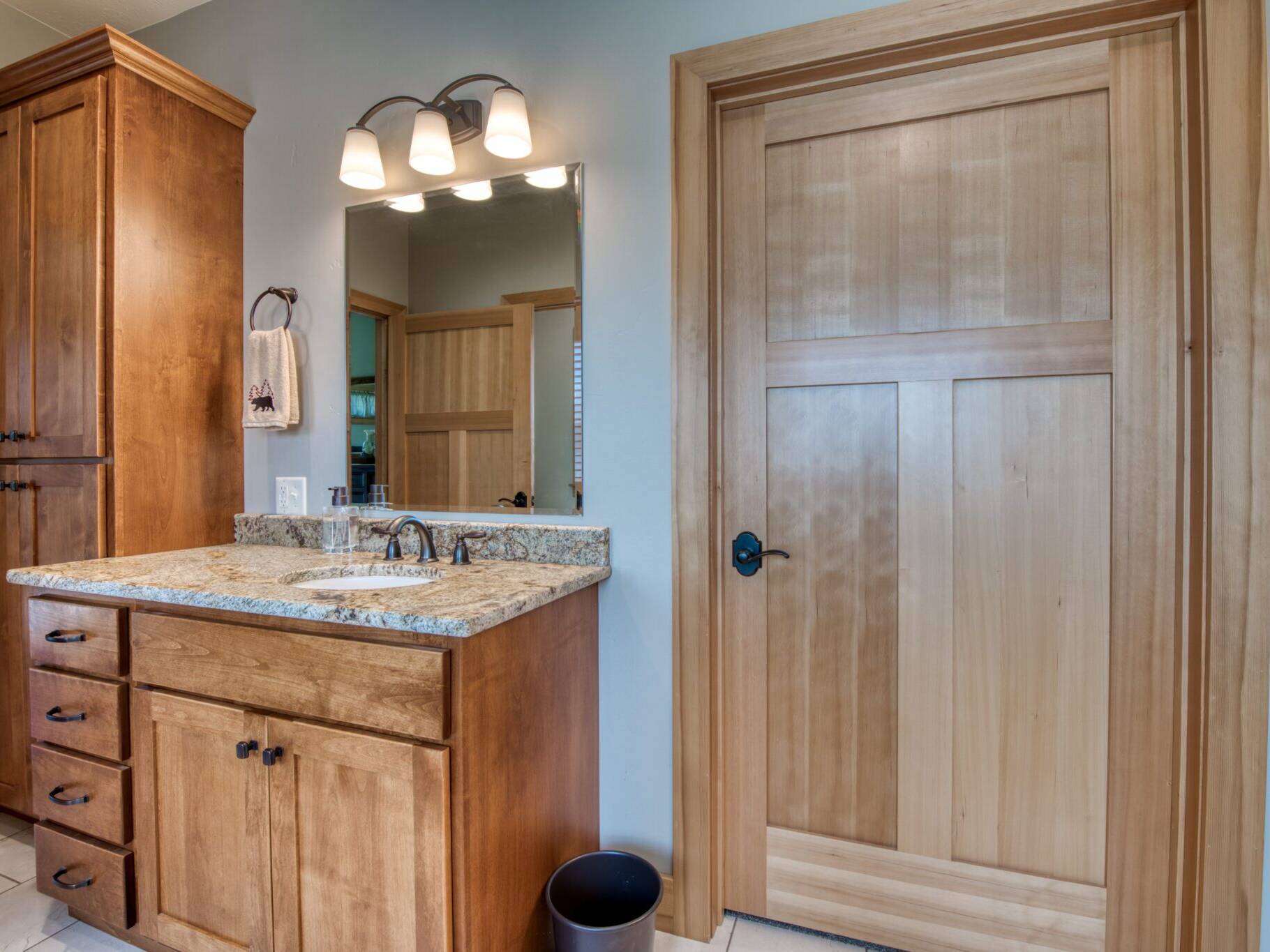 Master bathroom with tile flooring, wood cabinetry, trim and doors in a custom home near Hamilton, MT.
