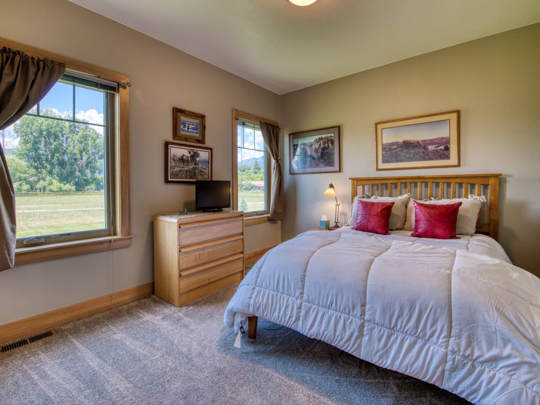 Guest bedroom with carpet flooring and wood trim in a custom home in Hamilton, MT.