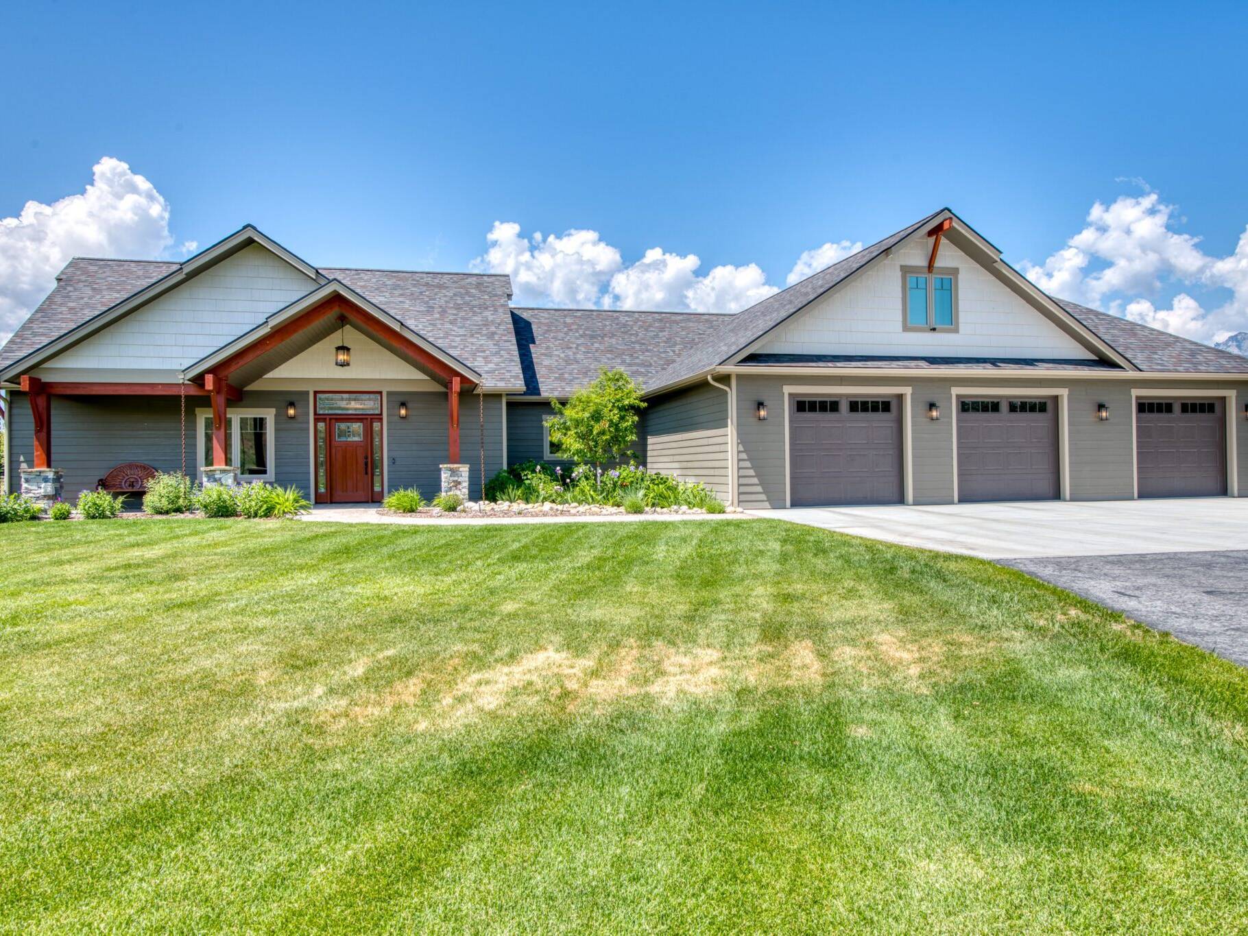 House exterior with a covered front porch with exposed beams in a custom home by Big Sky Builders in Hamilton, MT.