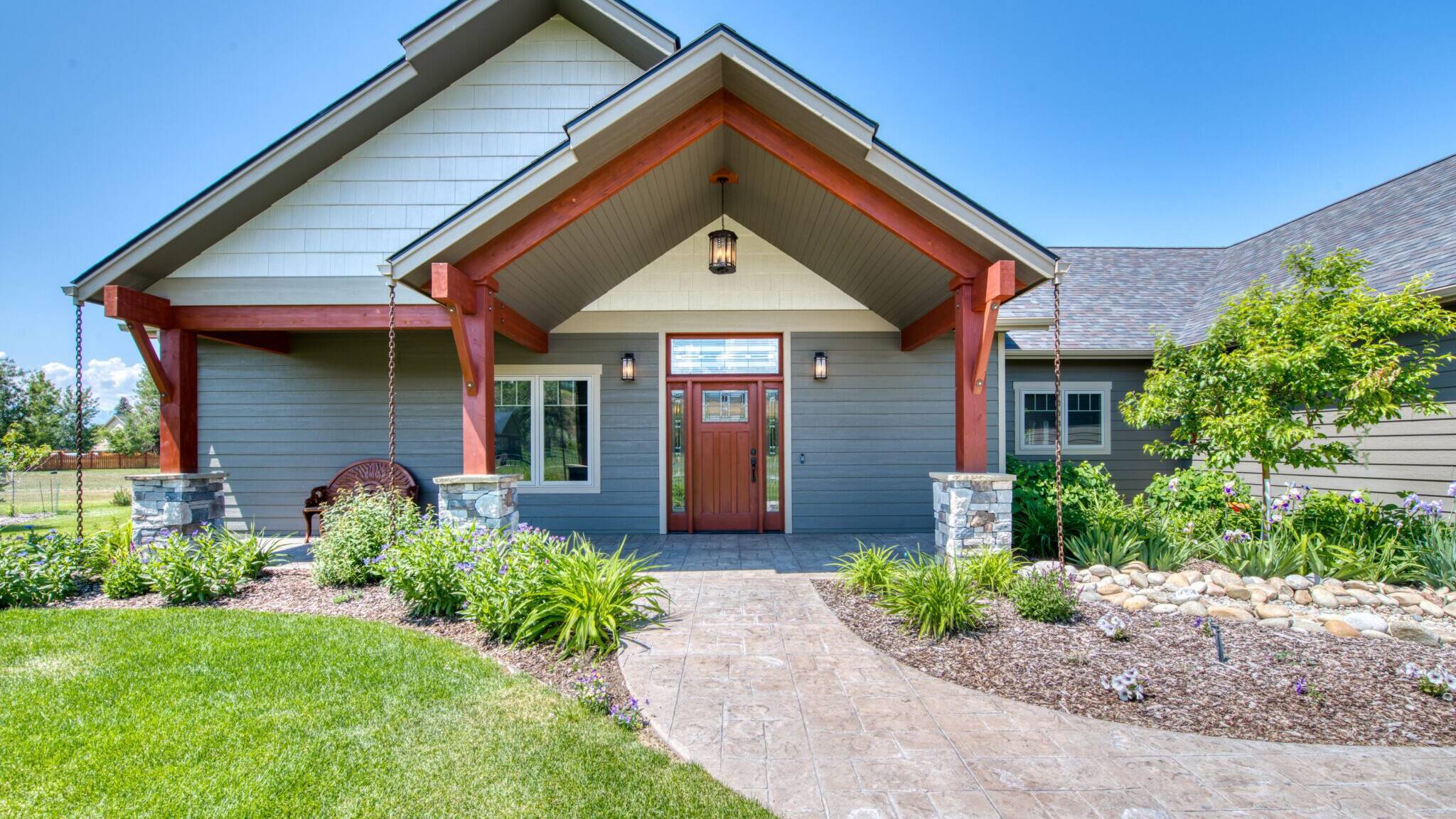 House exterior with a covered front porch with exposed beams in a custom home by Big Sky Builders in Hamilton, MT.