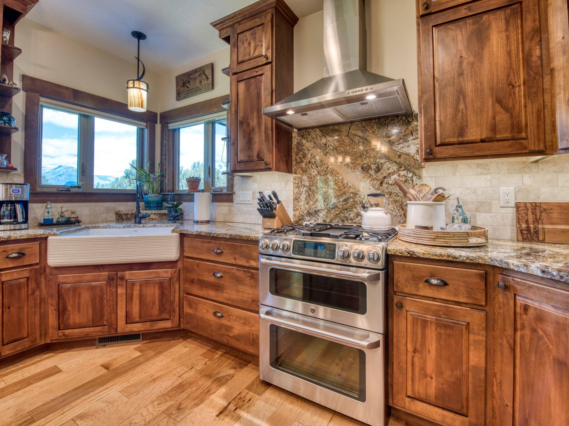 Kitchen with a corner sink with granite countertops, tile backsplash in a custom home near Hamilton, MT