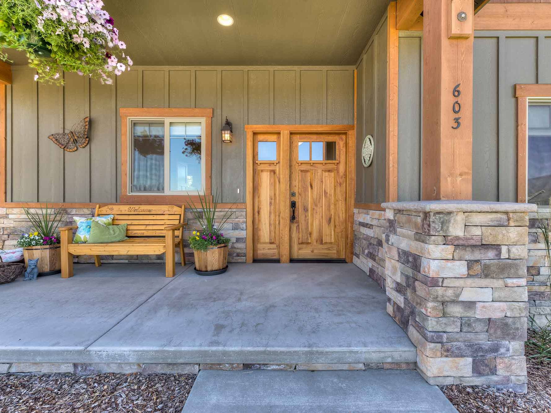 Front covered entry porch with a custom entry door of a custom home built by Big Sky Builders in Hamilton, MT