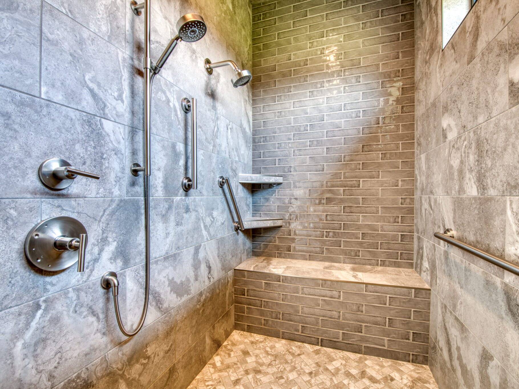 Tile shower with bench and grab bars in a custom home built by Big Sky Builders in Florence, MT