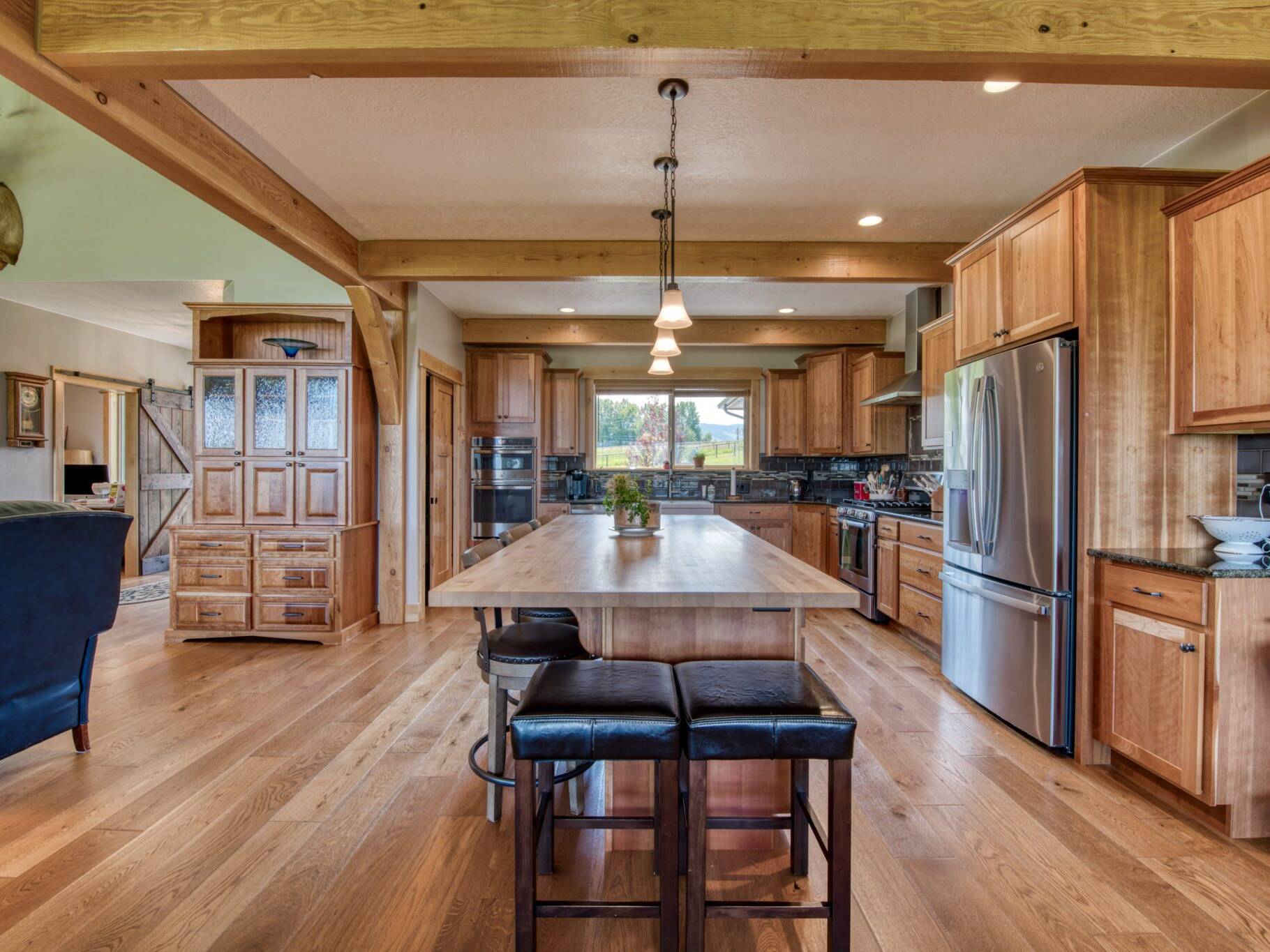 Kitchen with butcher block island countertop and wood beam work in a custom home built by Big Sky Builders in Stevensville, MT