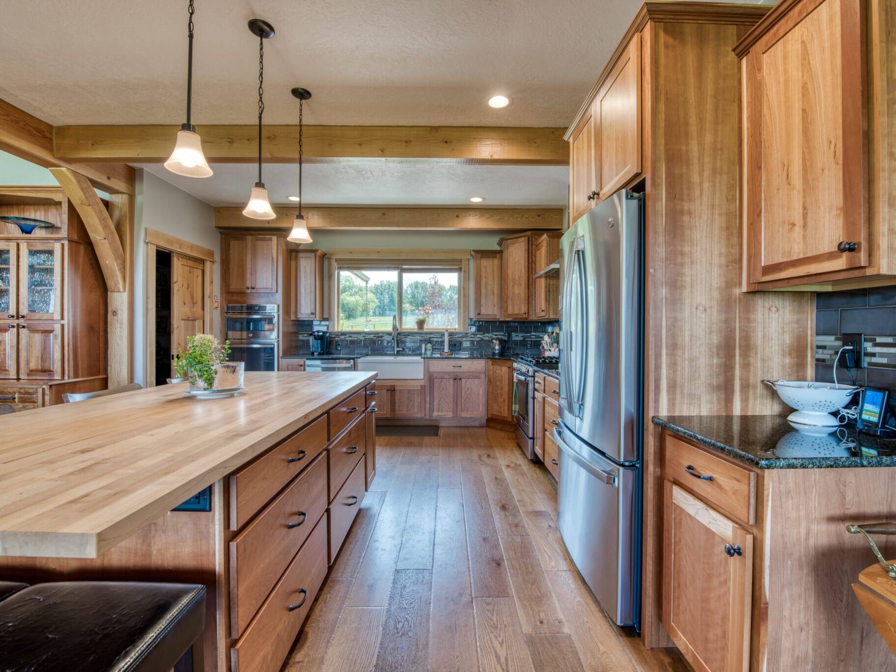 Kitchen with butcher block island countertop and wood beam work in a custom home built by Big Sky Builders in Stevensville, MT