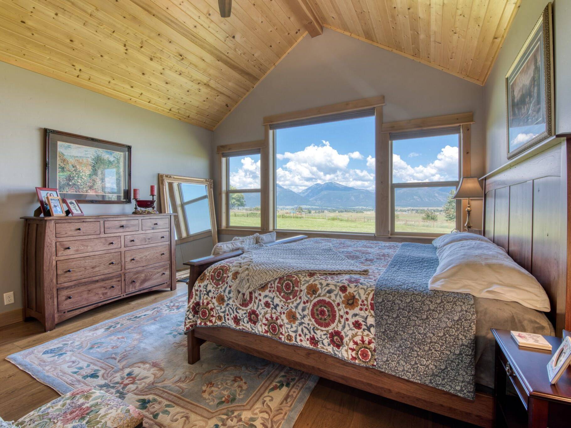 Master bedroom with a vaulted wood T&G pine ceiling in a custom home built by Big Sky Builders in Stevensville, MT