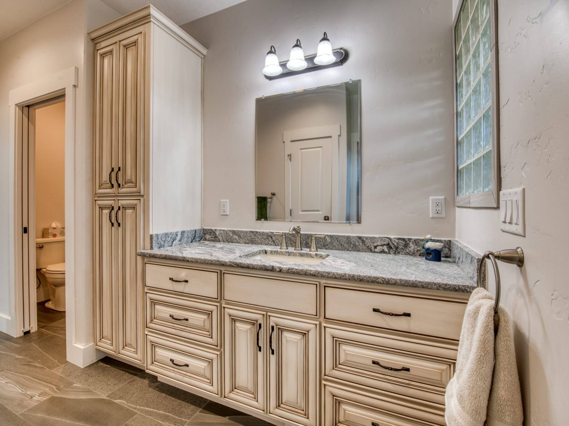 Master bathroom with tile floor, white glazed cabinets, granite countertops in a custom home built by Big Sky Builders in Stevensville, MT